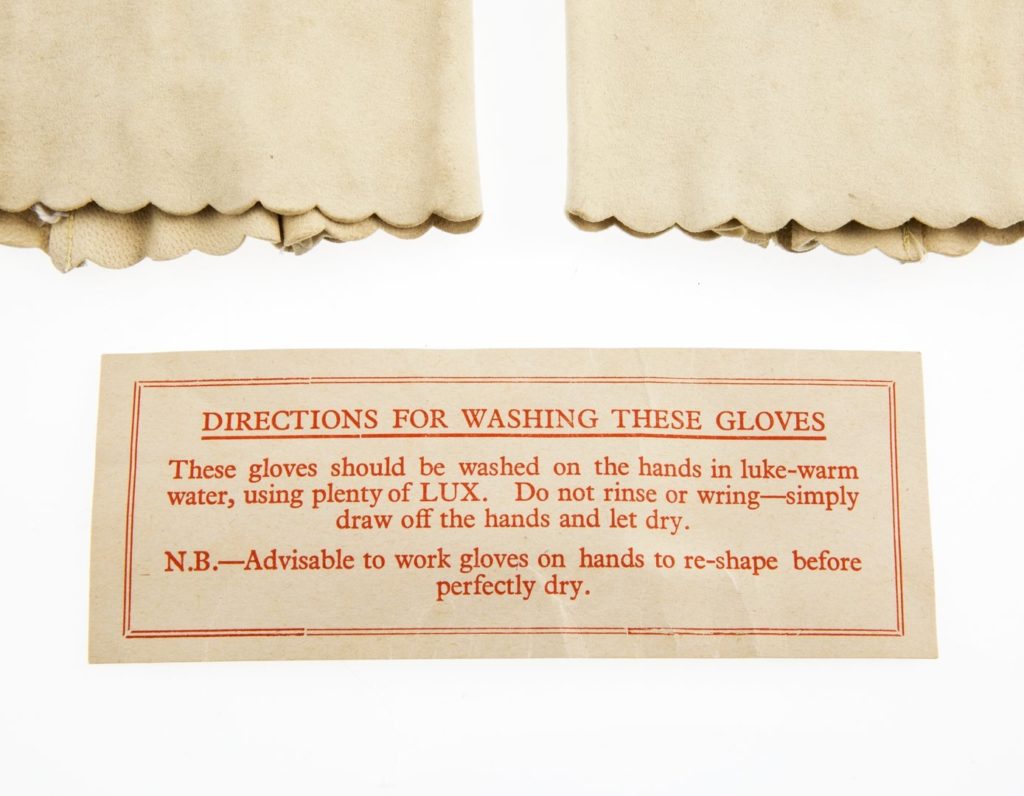 Label detailing washing instructions for pair of womenswear gauntlet-style gloves